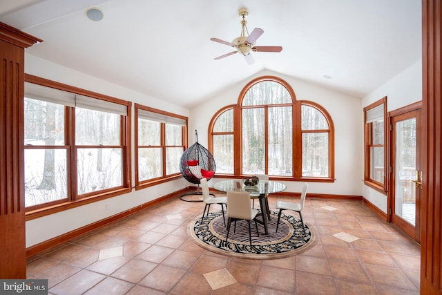 dining space with ceiling fan, light tile patterned floors, vaulted ceiling, and a healthy amount of sunlight