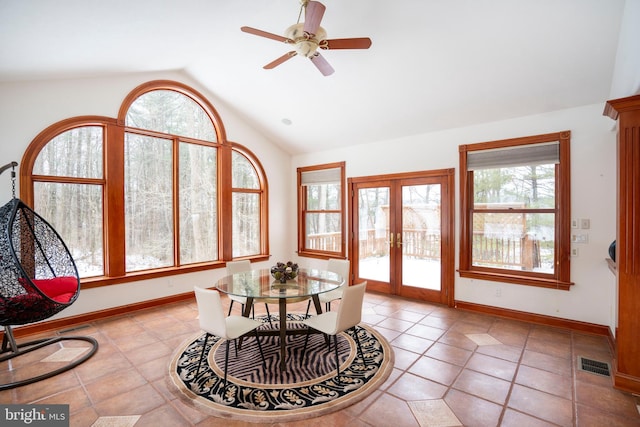 tiled dining area featuring ceiling fan, french doors, and vaulted ceiling