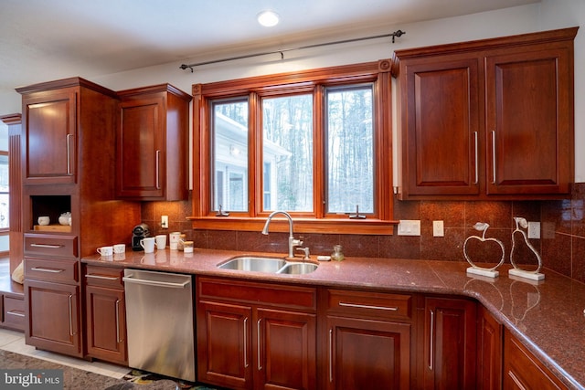 kitchen featuring dark stone countertops, decorative backsplash, sink, light tile patterned floors, and stainless steel dishwasher