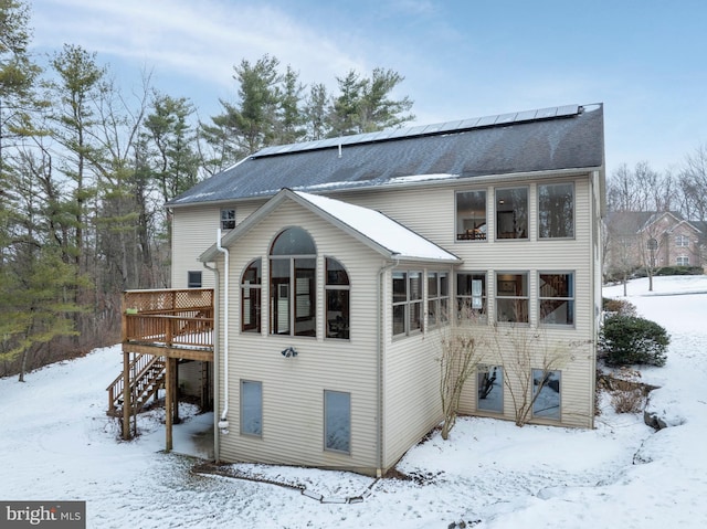 snow covered house featuring a deck