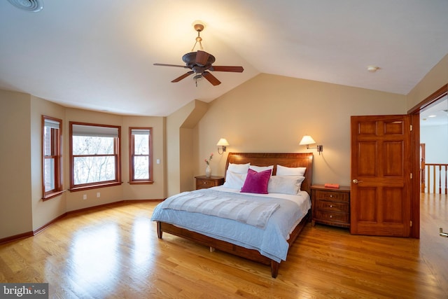 bedroom with ceiling fan, vaulted ceiling, and light wood-type flooring