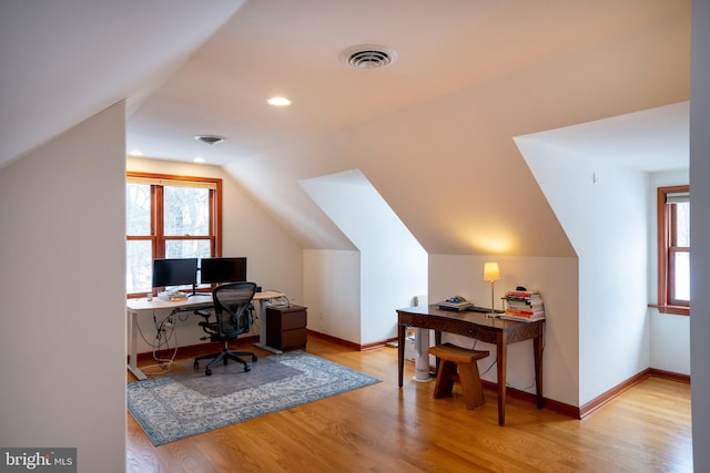 office featuring vaulted ceiling, plenty of natural light, and light hardwood / wood-style flooring