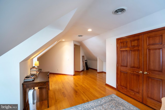 bonus room with lofted ceiling and light hardwood / wood-style flooring