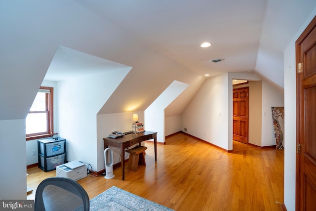 additional living space featuring lofted ceiling and light hardwood / wood-style flooring