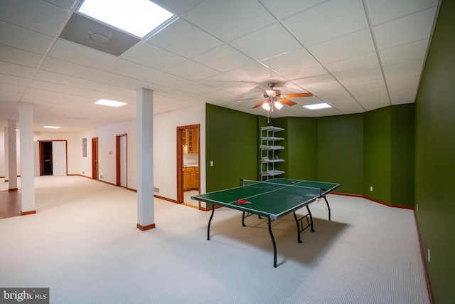 recreation room with ceiling fan, carpet, and a paneled ceiling