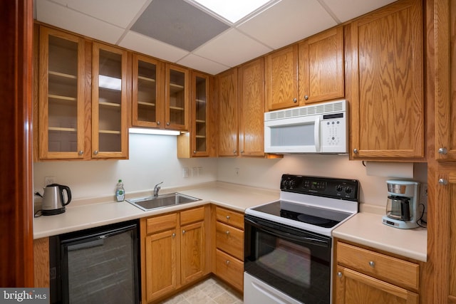 kitchen featuring sink, beverage cooler, a paneled ceiling, and range with electric cooktop