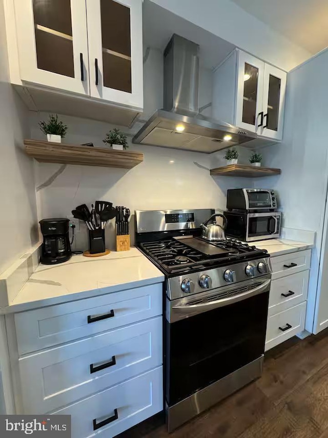 kitchen with stainless steel appliances, extractor fan, light countertops, and glass insert cabinets