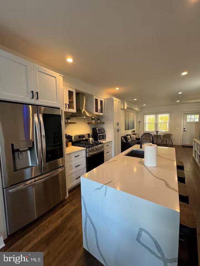 kitchen with stainless steel appliances, glass insert cabinets, white cabinets, a sink, and light stone countertops