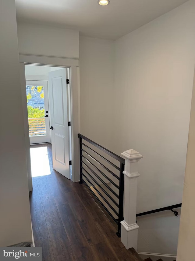 corridor featuring recessed lighting, dark wood finished floors, and an upstairs landing