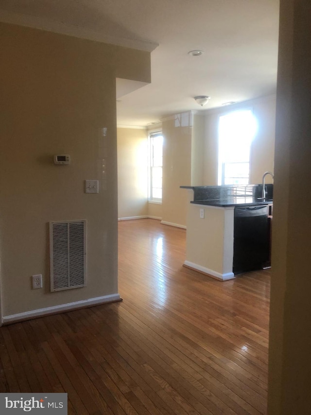 kitchen with black dishwasher, hardwood / wood-style floors, and kitchen peninsula