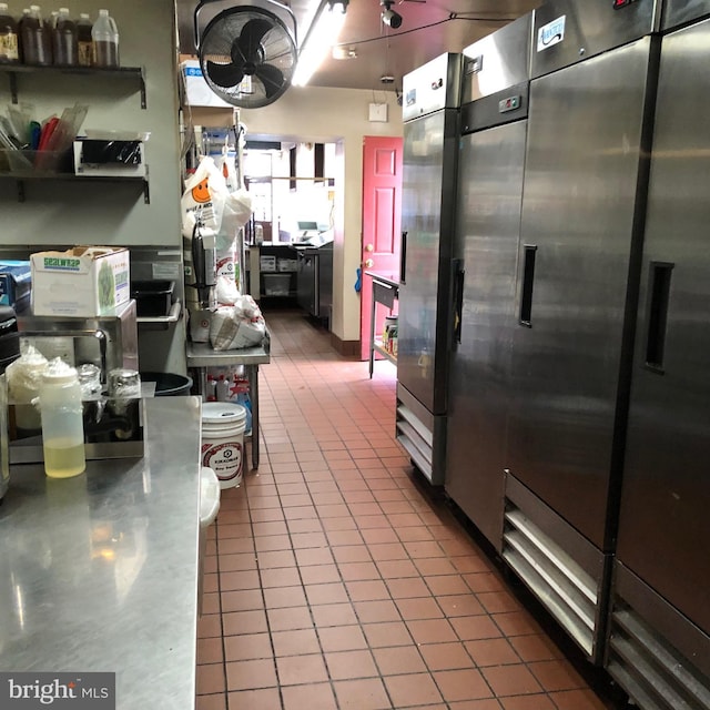 kitchen featuring stainless steel counters, stainless steel built in refrigerator, and dark tile patterned flooring