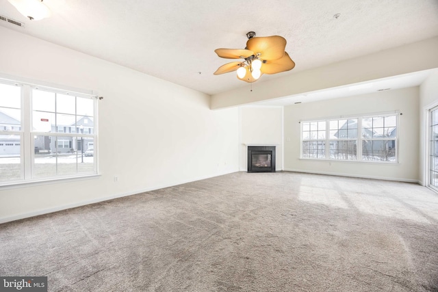 unfurnished living room with beam ceiling, carpet flooring, a textured ceiling, and ceiling fan