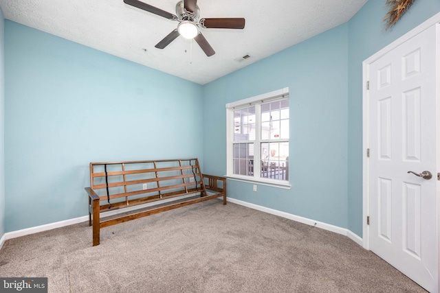 bedroom featuring ceiling fan, carpet, and a textured ceiling