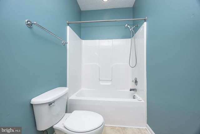 bathroom with a textured ceiling, bathtub / shower combination, and toilet