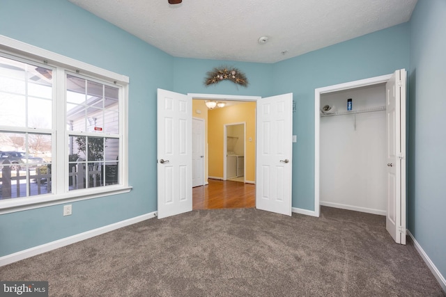 unfurnished bedroom with dark colored carpet, a textured ceiling, and a closet