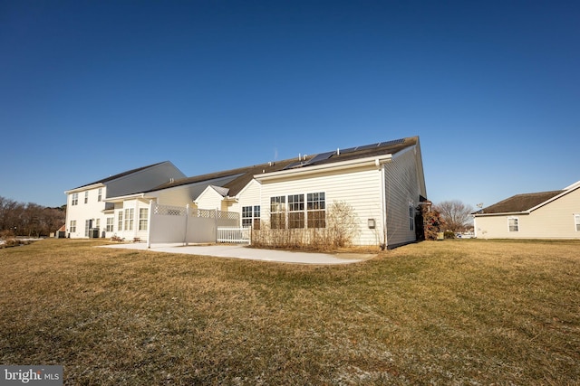 back of house featuring solar panels, a yard, and a patio area