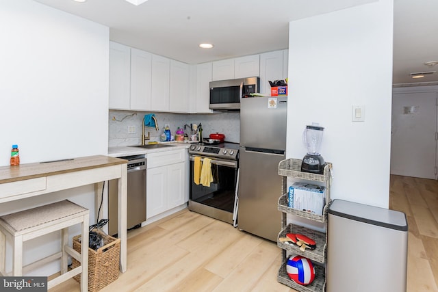 kitchen featuring decorative backsplash, sink, white cabinetry, and appliances with stainless steel finishes