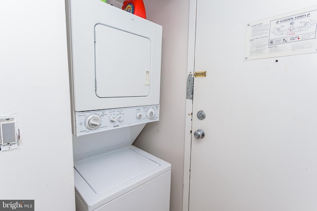 clothes washing area with stacked washer and clothes dryer