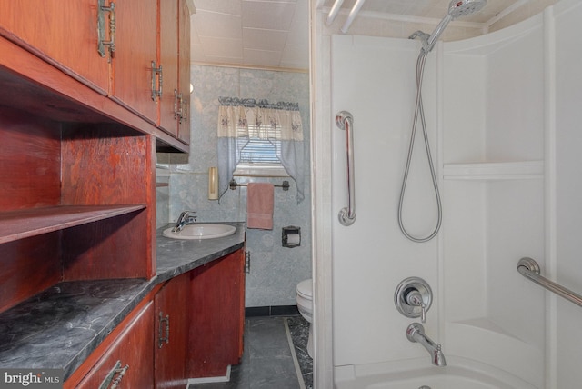 bathroom featuring toilet, a shower, and vanity