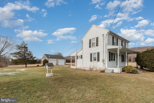 view of home's exterior featuring a yard, an outdoor structure, covered porch, and a garage