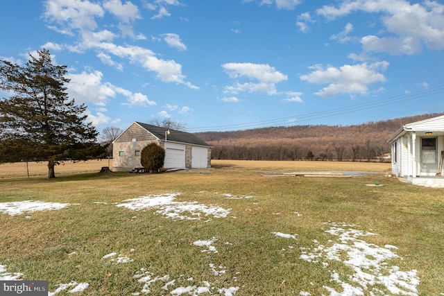 view of yard with a garage and an outbuilding