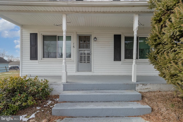 view of exterior entry featuring covered porch