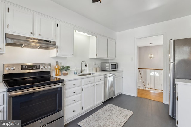 kitchen featuring sink, decorative light fixtures, appliances with stainless steel finishes, dark hardwood / wood-style floors, and white cabinets