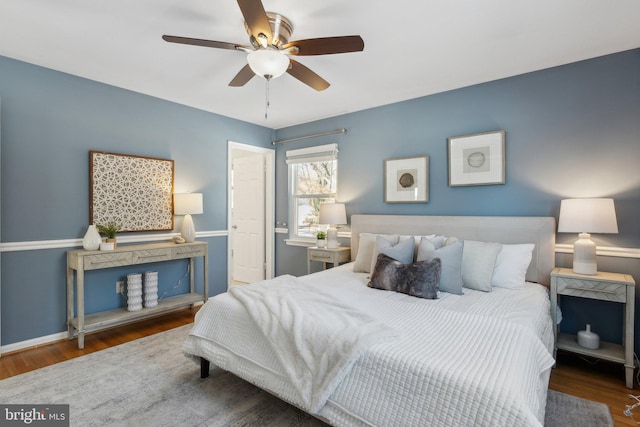 bedroom with dark hardwood / wood-style flooring and ceiling fan