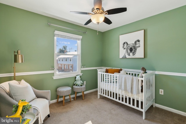 bedroom featuring a crib, carpet floors, and ceiling fan