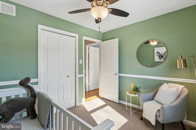 bedroom with light carpet, ceiling fan, and a closet