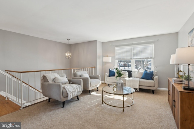 carpeted living room with a chandelier