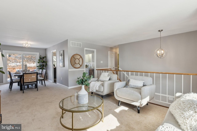 carpeted living room with an inviting chandelier