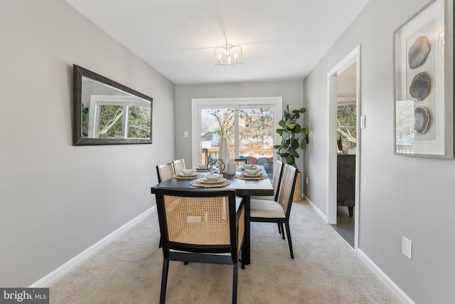 carpeted dining space featuring a chandelier