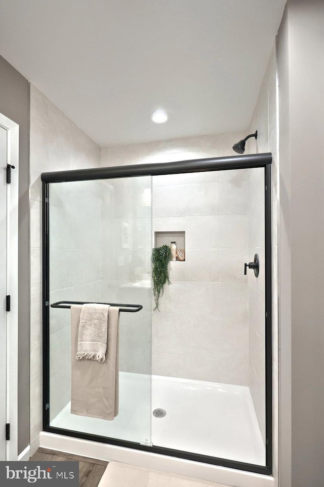 bathroom featuring hardwood / wood-style flooring and an enclosed shower