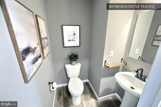 bathroom featuring hardwood / wood-style flooring, sink, and toilet