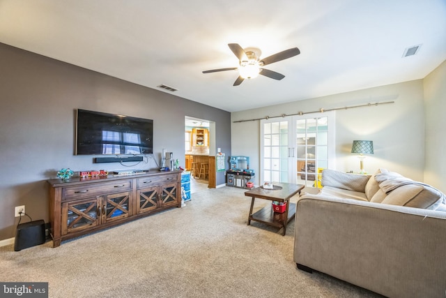 living room featuring ceiling fan and french doors