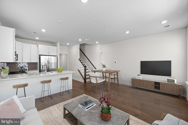 living room featuring dark hardwood / wood-style flooring and sink