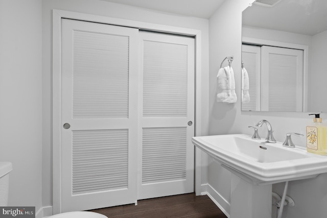 bathroom with toilet, hardwood / wood-style flooring, and sink