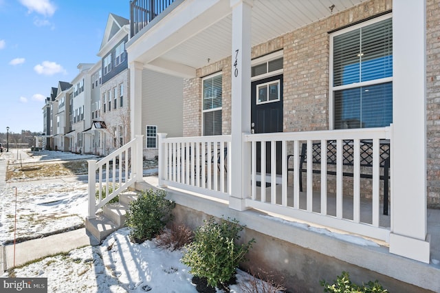 view of snowy exterior featuring a porch