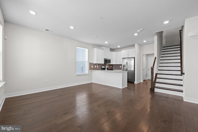 unfurnished living room with dark wood-type flooring and sink