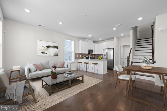 living room featuring dark wood-type flooring and sink