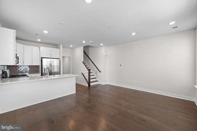 kitchen featuring white cabinets, dark hardwood / wood-style flooring, decorative backsplash, stainless steel fridge with ice dispenser, and stove