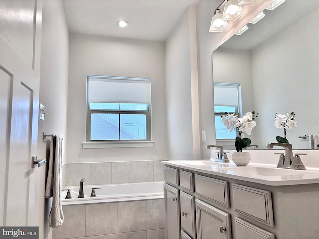 bathroom with a relaxing tiled tub and vanity