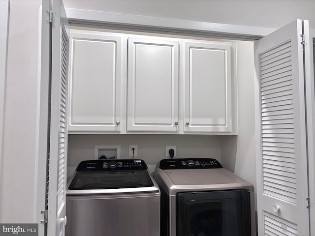 washroom featuring washer and clothes dryer and cabinets