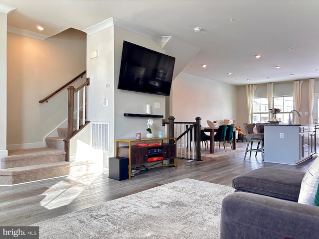 living room with crown molding and hardwood / wood-style flooring