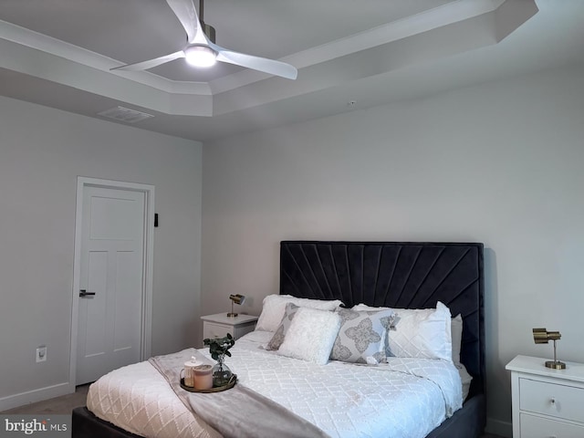 bedroom featuring ceiling fan, a tray ceiling, and crown molding