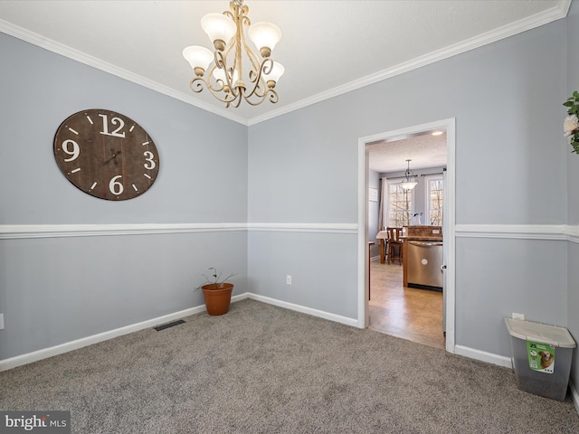 spare room with crown molding, carpet, and a notable chandelier