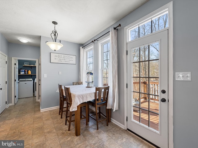 dining area featuring washer / clothes dryer, a wealth of natural light, and a textured ceiling