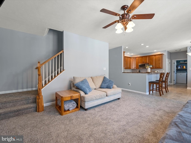 carpeted living room with ceiling fan