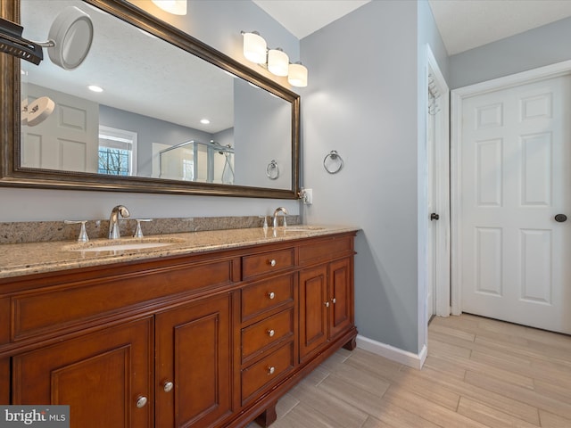 bathroom featuring vanity, a shower with shower door, and wood-type flooring